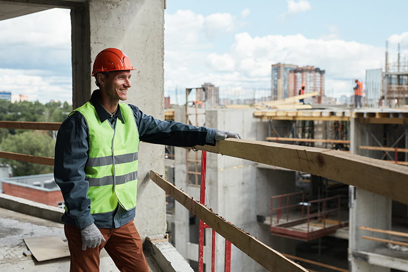 Construction worker smiling knowing he holds a tradesman public liability insurance policy